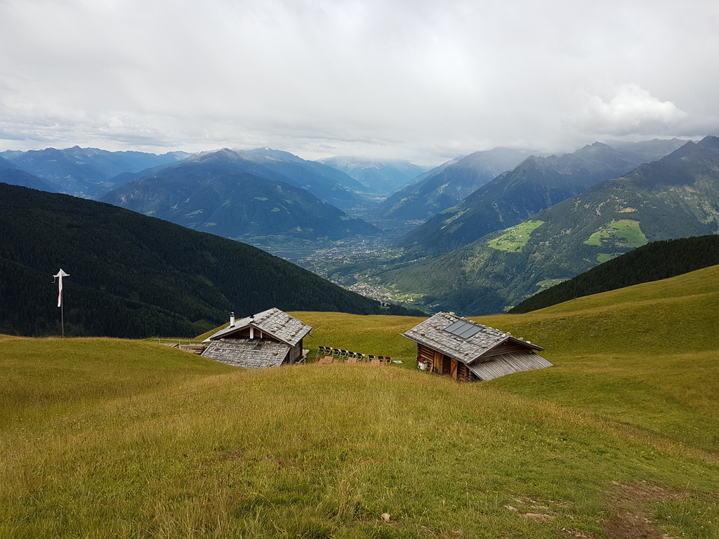 Ausblick auf die beiden Gebäude der Assenhütte und das herrliche Panorama mit Meran, Texel- und Ortlergruppe sowie dem Vinschgau