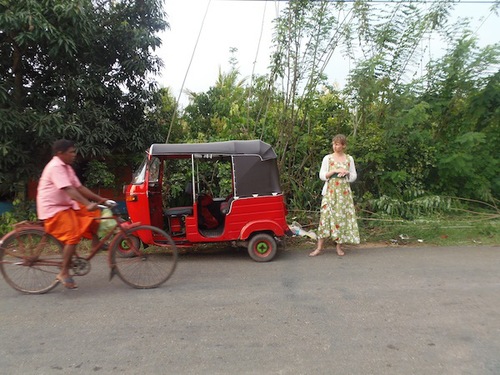 Nadja wartet neben dem roten Tuk Tuk am Straßenrand