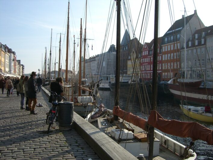 Blick auf die bunten Häuser und Segelschiffe im Hafenarm von Nyhavn