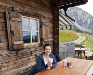 Martina mit einem Glas Buttermilch vor der Assenhütte