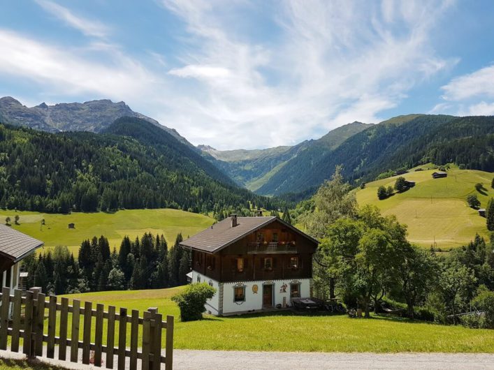 Ausblick auf altes Bauernhaus und die karnischen Alpen in Maria Luggau im Lesachtal