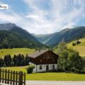 Werbung, da Pressereise - Ausblick auf Bauerhaus und umliegende Bergwelt in Maria Luggau in Kärnten