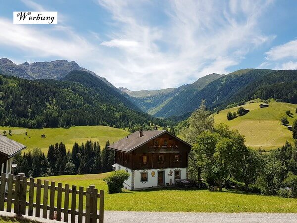 Werbung, da Pressereise - Ausblick auf Bauerhaus und umliegende Bergwelt in Maria Luggau in Kärnten