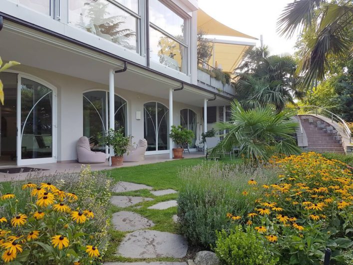 Gartenanlage mit Außentreppe und Blick auf die Terrasse beim Wellnesshotel Sonnbichl