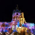 Blick auf das erleuchtete Schloss Charlottenburg und die Dächer der Weihnachtsmarktbuden