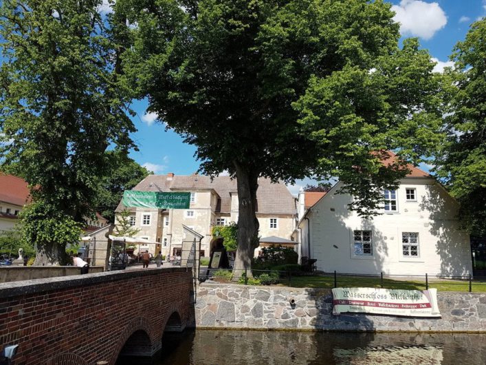 Blick auf das Wasserschloss Mellenthin und die Brücke über den Wassergraben