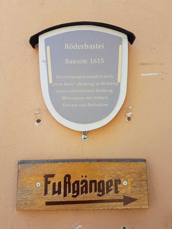 Schild mit Erklärungen zum Rödertor in Rothenburg und Fußgängerhinweis