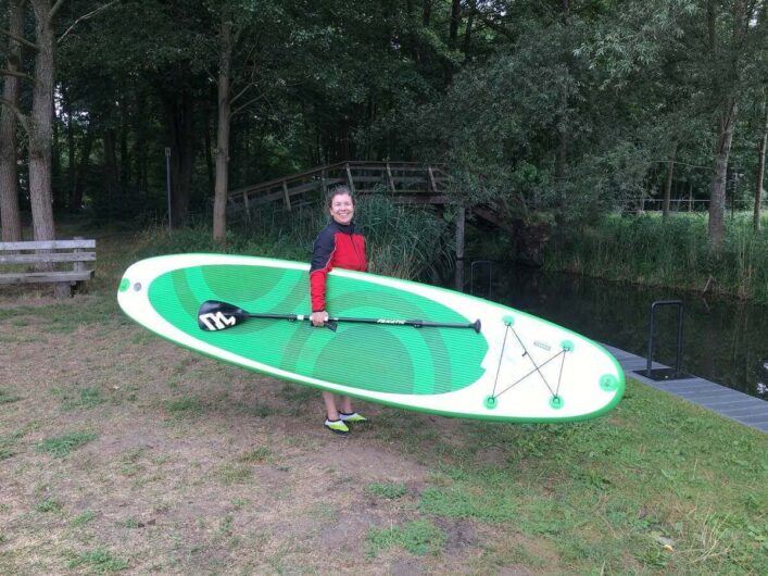 Martina startklar zum Standup Paddling mit Board unter dem Arm