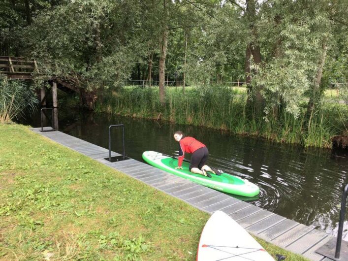 Martina steigt kniend auf das Board