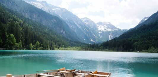 2 Holzboote auf dem grün-blau schimmernden Jägersee vor einer Bergkulisse