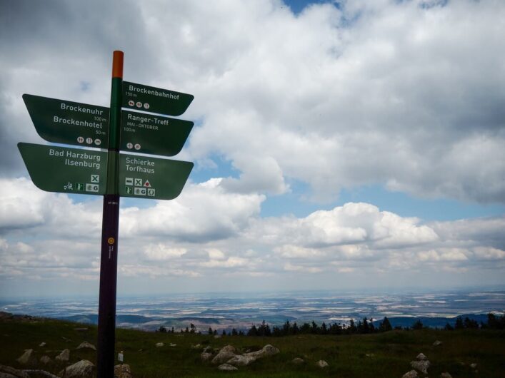 Wanderwegweiser und Fernblick auf dem Brocken