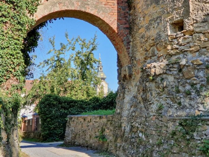 Blick durch die Stadtmauer Richtung Altstadt Hartberg und Kirche St. Martin