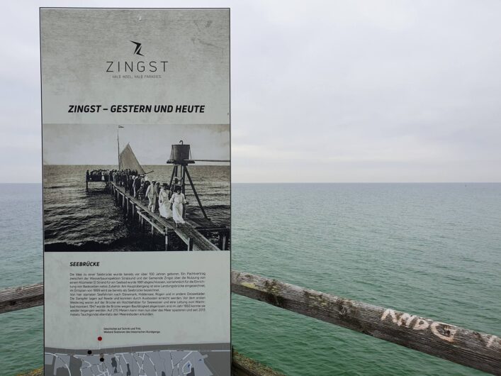 Ein Schild des historischen Rundgangs in Zingst auf der Seebrücke