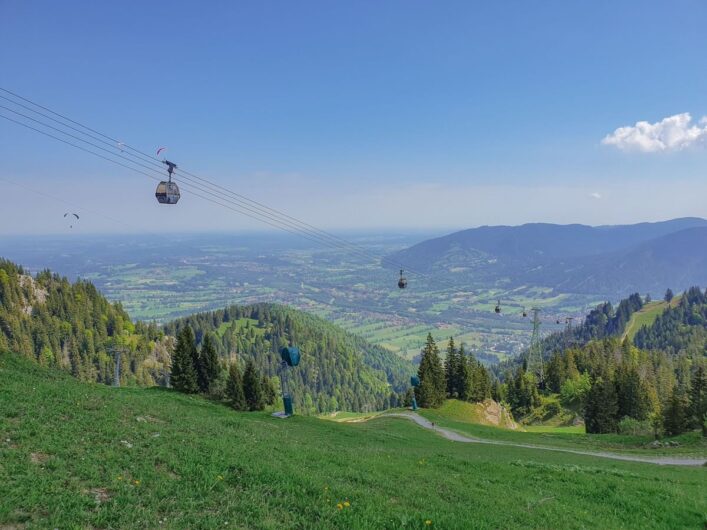 Gondeln der Brauneck-Bergbahn vor dem Panorama des Voralpenlands