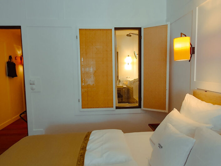 Fenster mit Fensterläden vom Courtyard-Deluxe-Room ins Badezimmer