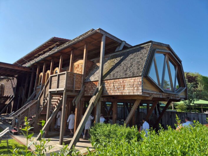 Außenansicht der Gradierwerksauna in der Börde-Therme Bad Sassendorf mit markanter Holzkonstruktion, großen Fenstern und einer Außentreppe.
