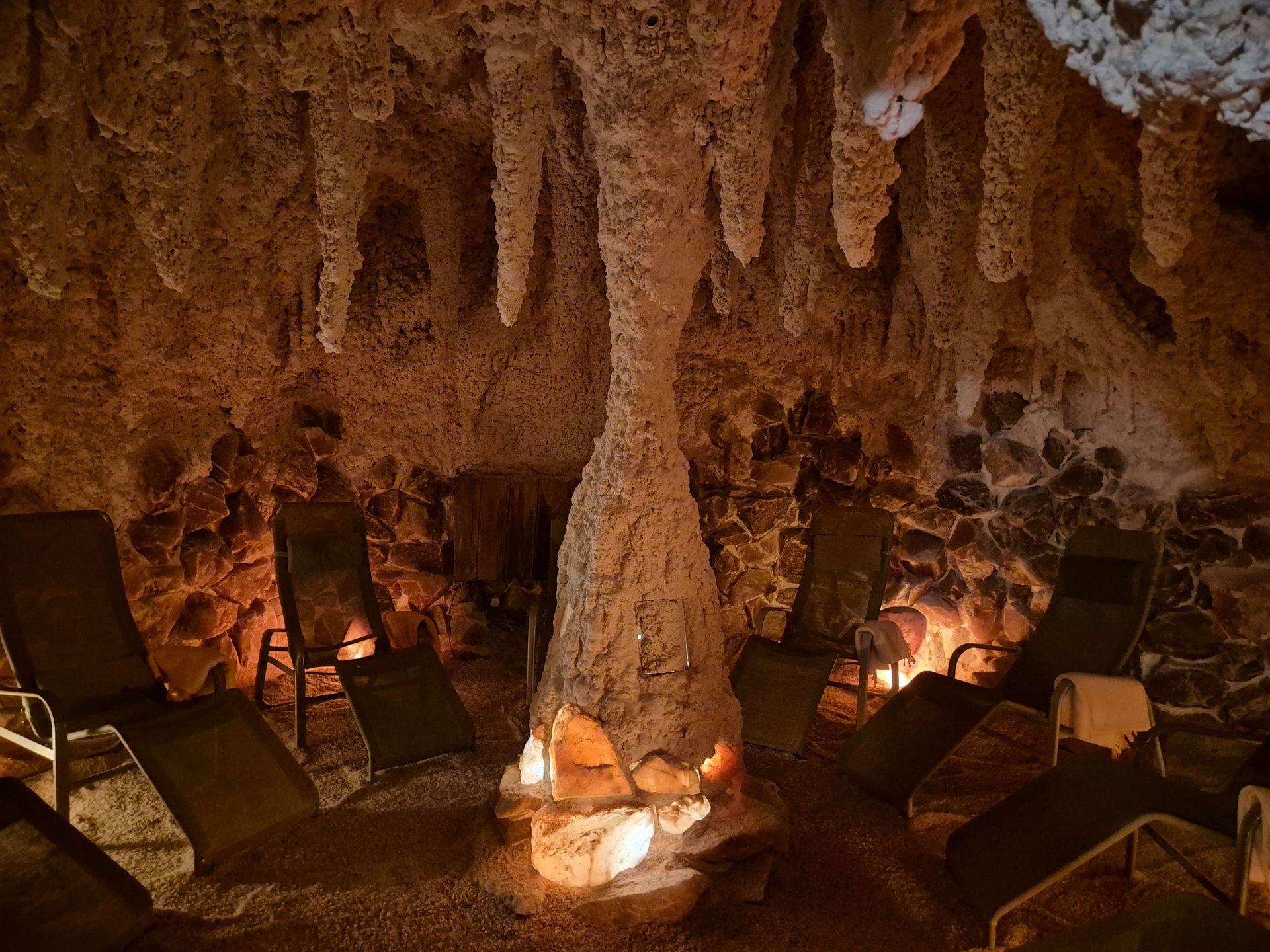 Ruhig gestaltete Meersalzgrotte mit bequemen Liegestühlen, salzbedeckten Wänden und warmem Licht zum Entspannen.