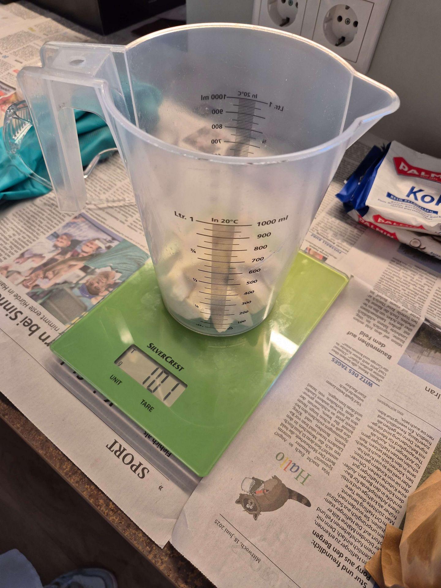 Messbecher mit abgewogenem Kokosfett auf einer digitalen Küchenwaage beim Seifenworkshop in den Salzwelten Bad Sassendorf.